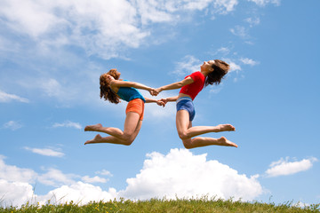 Jumping girls on meadow