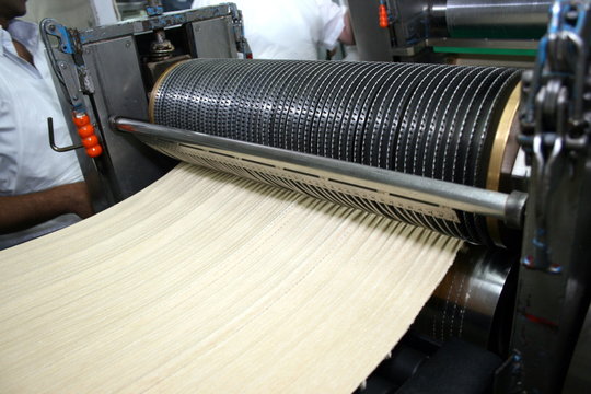 Flattened Dough Passing Through a Roller