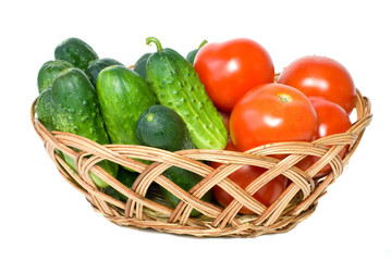 Basket with tomatoes and cucumbers isolated on the white