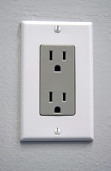 A white electrical outlet with gray plate for US power