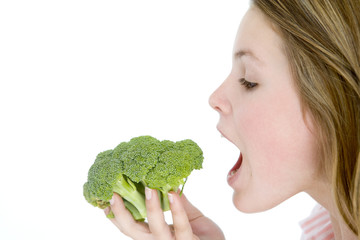 Teenage girl eating broccoli