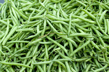 Long green beans heaped at a market..
