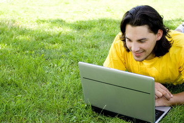 Young man using laptop outdoors