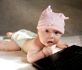 baby girl playing with portable computer