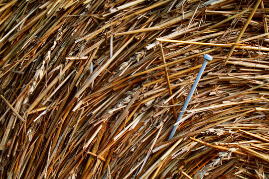 A knitting needle stuck in a haybale