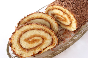 Swiss roll with two cut off slices on a glass dish