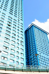 Two modern apartment skyscrapers against blue sky