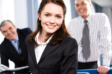 Portrait of smiling businesspeople with woman in front