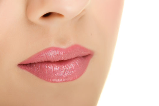 Closeup of a womans pink lips with a beautiful soft skin.