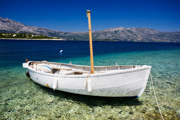 Naklejka na ściany i meble White fishing boat with a wooden mast