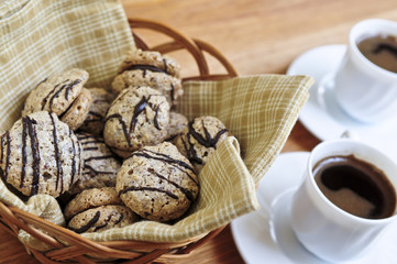 Fresh sandwich cookies in a basket and espresso coffee