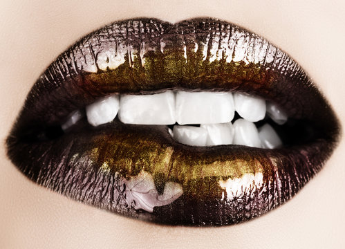 Woman biting her lips with black glossy lipstick