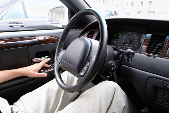 driver siting in a car and steering wheel