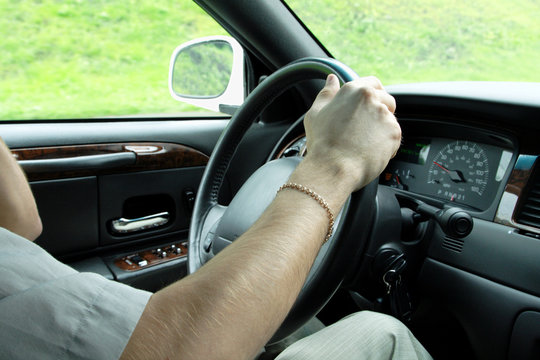 driver holding steering wheel in a luxury car