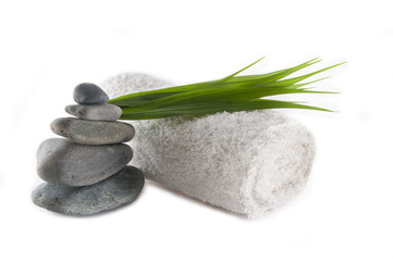towel and stack of rocks with bamboo leaves