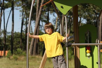 Obraz premium garçon avec des lunettes entrain de jouer sur une aire de jeux