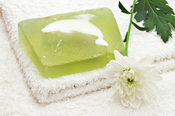 Obraz na płótnie Canvas green soap on white towel and flower