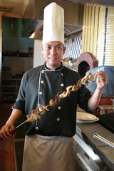chef holding grilled chiken kebab