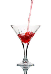 Closeup of pouring a red cocktail into glass