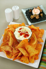 Nachos and Mexican dip topped with sour cream
