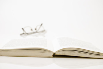Book with eyeglasses at background