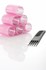 curlers and comb on a white background