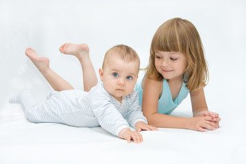 little brother and sister playing together, on white