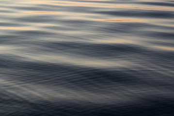 Water surface with small waves at sunset