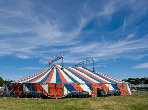 Le chapiteau bleu blanc rouge d'un cirque install&eacute; dans un champ