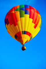 Obraz premium Multicoloured balloon flying in the clean blue sky.
