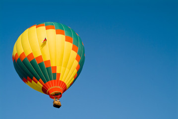 A colorful hot air balloon floating in a bright blue sky.