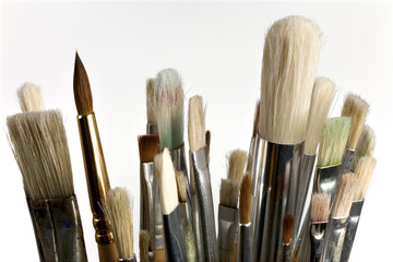 Old abluted paintbrushes on white background