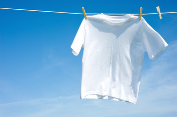 A plain white T-shirt hanging on a clothesline