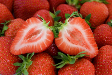Fresh strawberry fruit cut in half close-up image