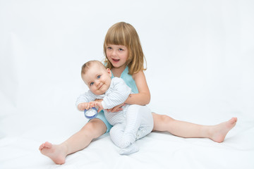 little brother and sister playing together, on white