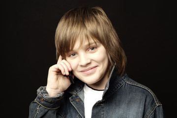 Young handsome calling boy on black background