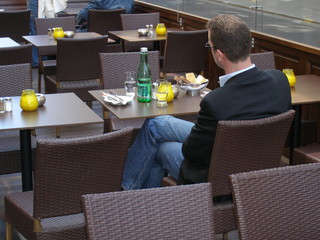 Mann sitzt alleine in strassencafe
