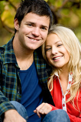 A young couple sitting together outside