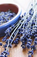 Bunch of dried lavender herb and lavender flowers in a bowl