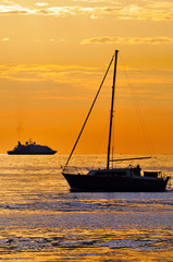 Barca vela e yacht al tramonto
