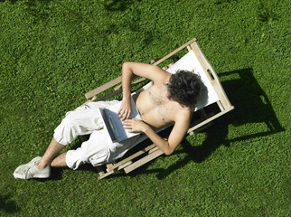 ragazzo al computer in giardino