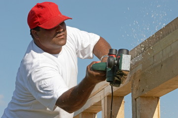 Worker man polishing wood frame on anew construction