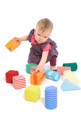 Little baby girl (9 months old) playing with toy blocks.