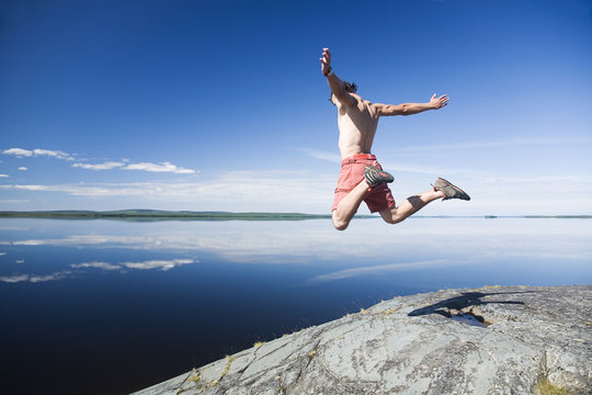 young man jumping on a rock