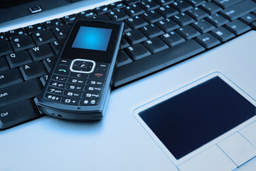 Close up shot of mobile phone and a computer laptop