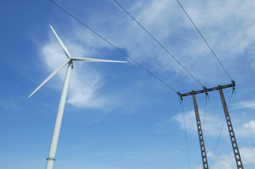a windturbine close to a electric pylon in France
