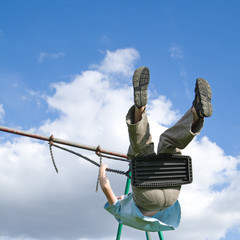 young boy on a swing, flying very high,