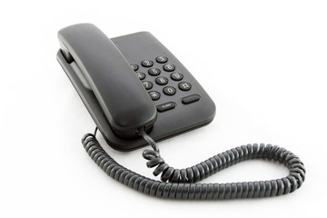 Black office telephone on a white background.