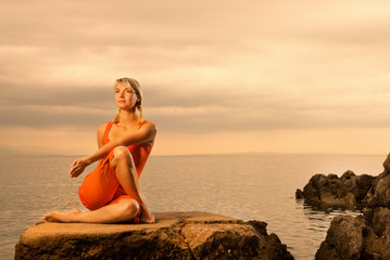 Fototapeta na wymiar Beautiful young woman doing yoga exercise outdoors