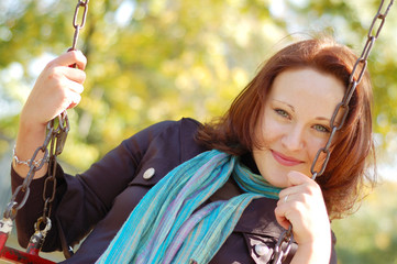 attractive girl on the seesaw in in autumn park